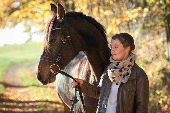 Frau mit Pferd an einem herbstlichen Tag